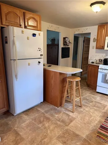a view of kitchen with stainless steel appliances granite countertop cabinets and a refrigerator