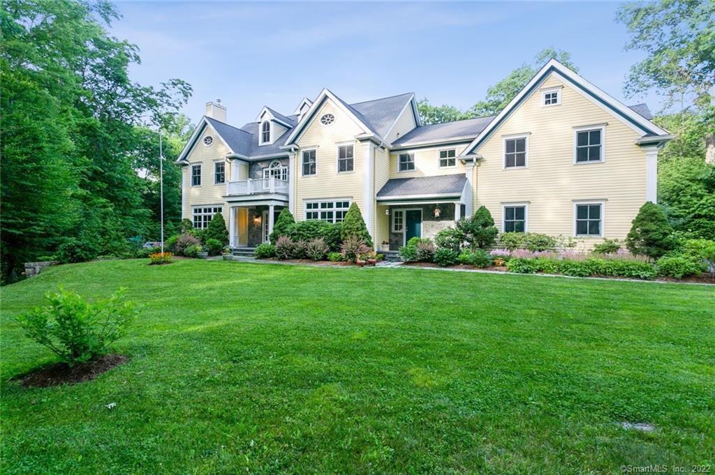 a view of a house with a yard and potted plants