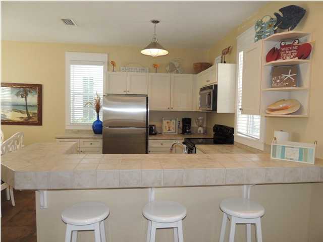 134 Somerset Bridge Road Santa Rosa Beach, FL 32459 - Photo 23 of 36 a kitchen with stainless steel appliances granite countertop a sink a stove a refrigerator cabinets and chairs