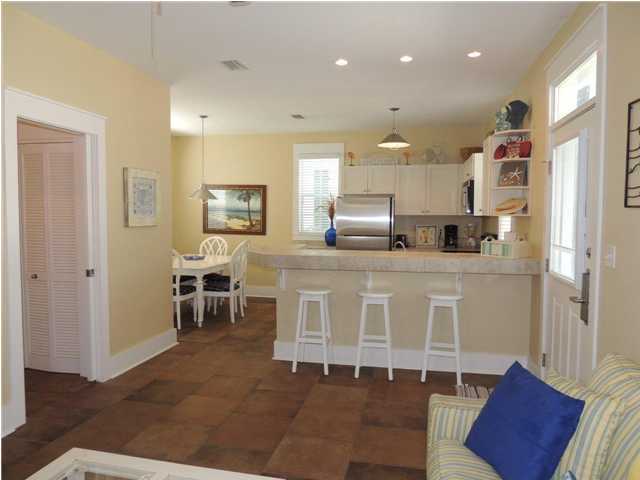 134 Somerset Bridge Road Santa Rosa Beach, FL 32459 - Photo 25 of 36 a kitchen with stainless steel appliances kitchen island granite countertop a table chairs sink and cabinets