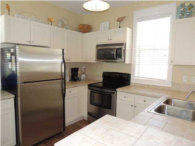 134 Somerset Bridge Road Santa Rosa Beach, FL 32459 - Photo 9 of 36 a kitchen with a refrigerator sink and cabinets