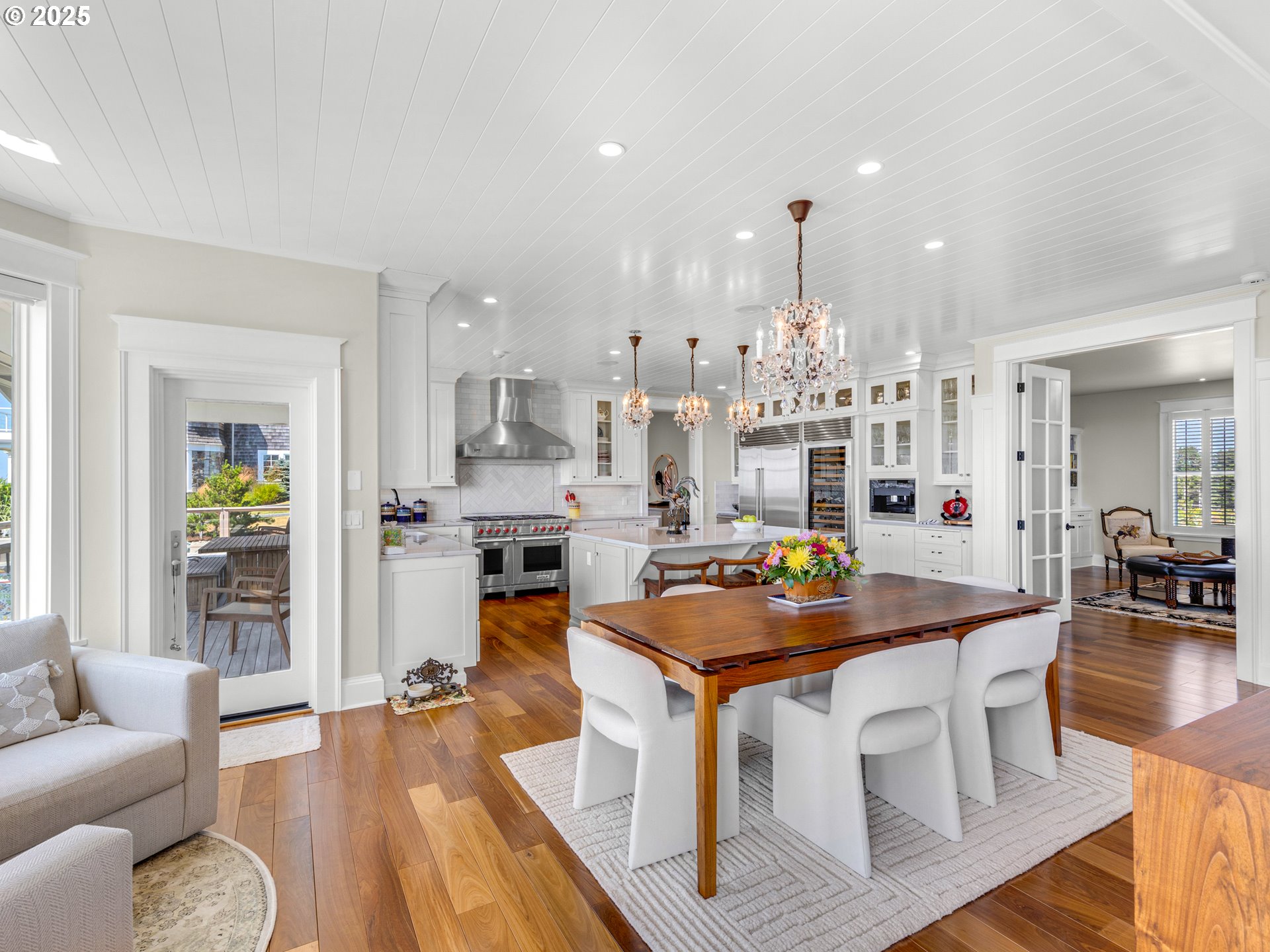 89062 Pinehurst Road Gearhart, OR 97138 - Photo 12 of 42 a kitchen with stainless steel appliances granite countertop a stove top oven a dining table and chairs with wooden floor
