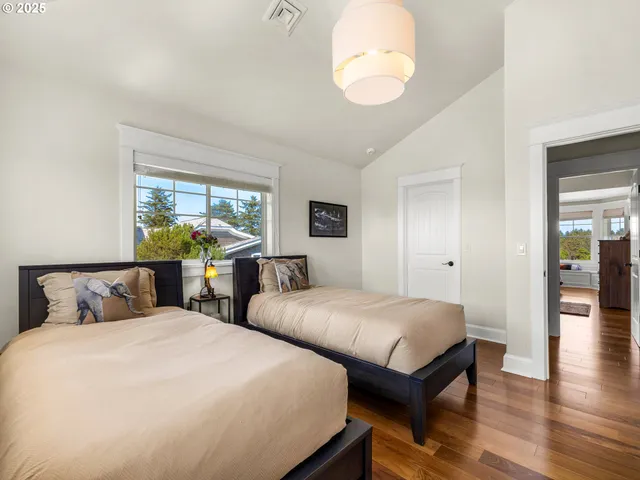 a bedroom with two beds and a large window