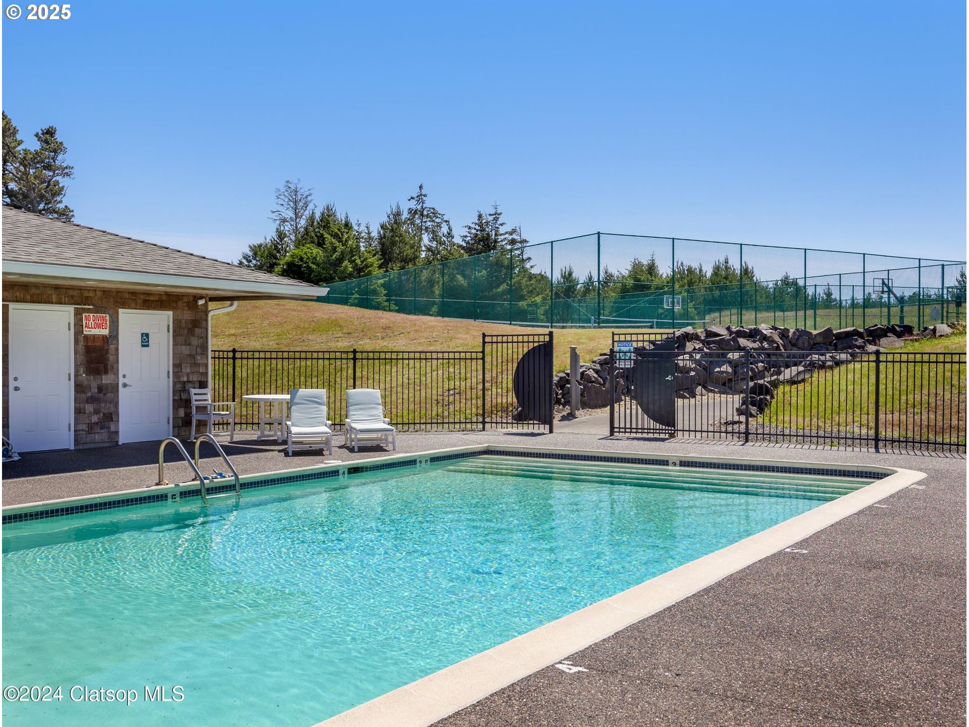 89062 Pinehurst Road Gearhart, OR 97138 - Photo 41 of 42 a view of a swimming pool and lounge chairs in back yard of a house