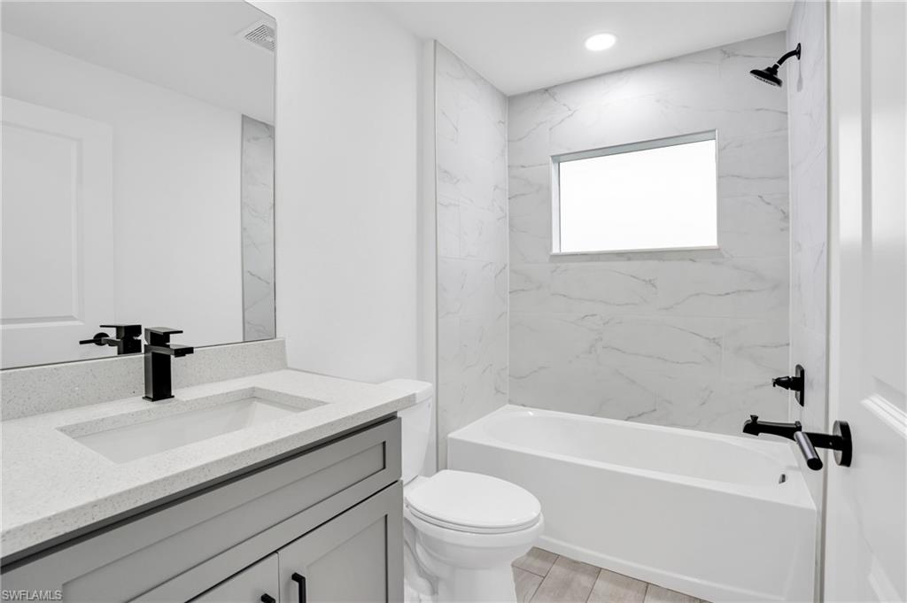2719 29th Street Southwest Lehigh Acres, FL 33976 - Photo 13 of 23 a bathroom with a sink a toilet and shower