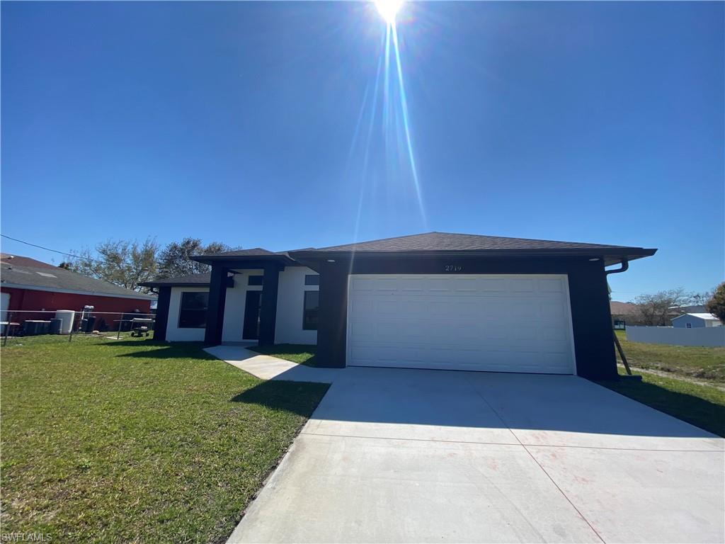 2719 29th Street Southwest Lehigh Acres, FL 33976 - Photo 22 of 23 a view of a house with a yard and a garage