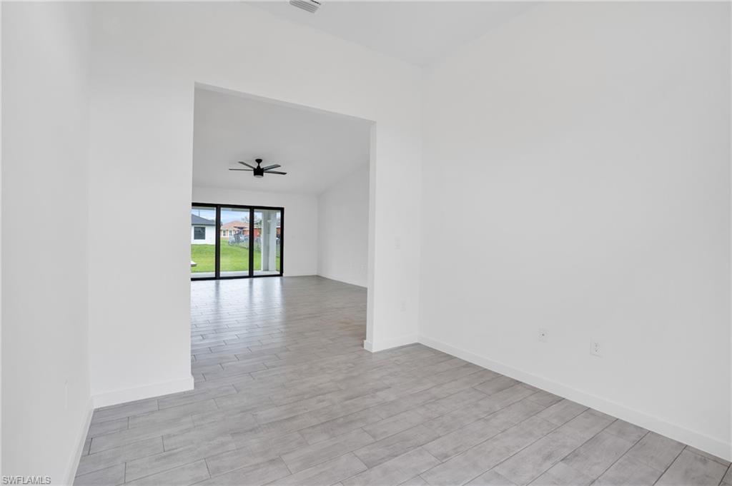 2719 29th Street Southwest Lehigh Acres, FL 33976 - Photo 5 of 23 a view of an empty room with wooden floor and a window