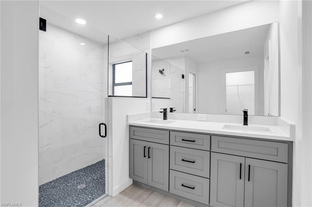 2719 29th Street Southwest Lehigh Acres, FL 33976 - Photo 8 of 23 a bathroom with double sink a mirror and a shower