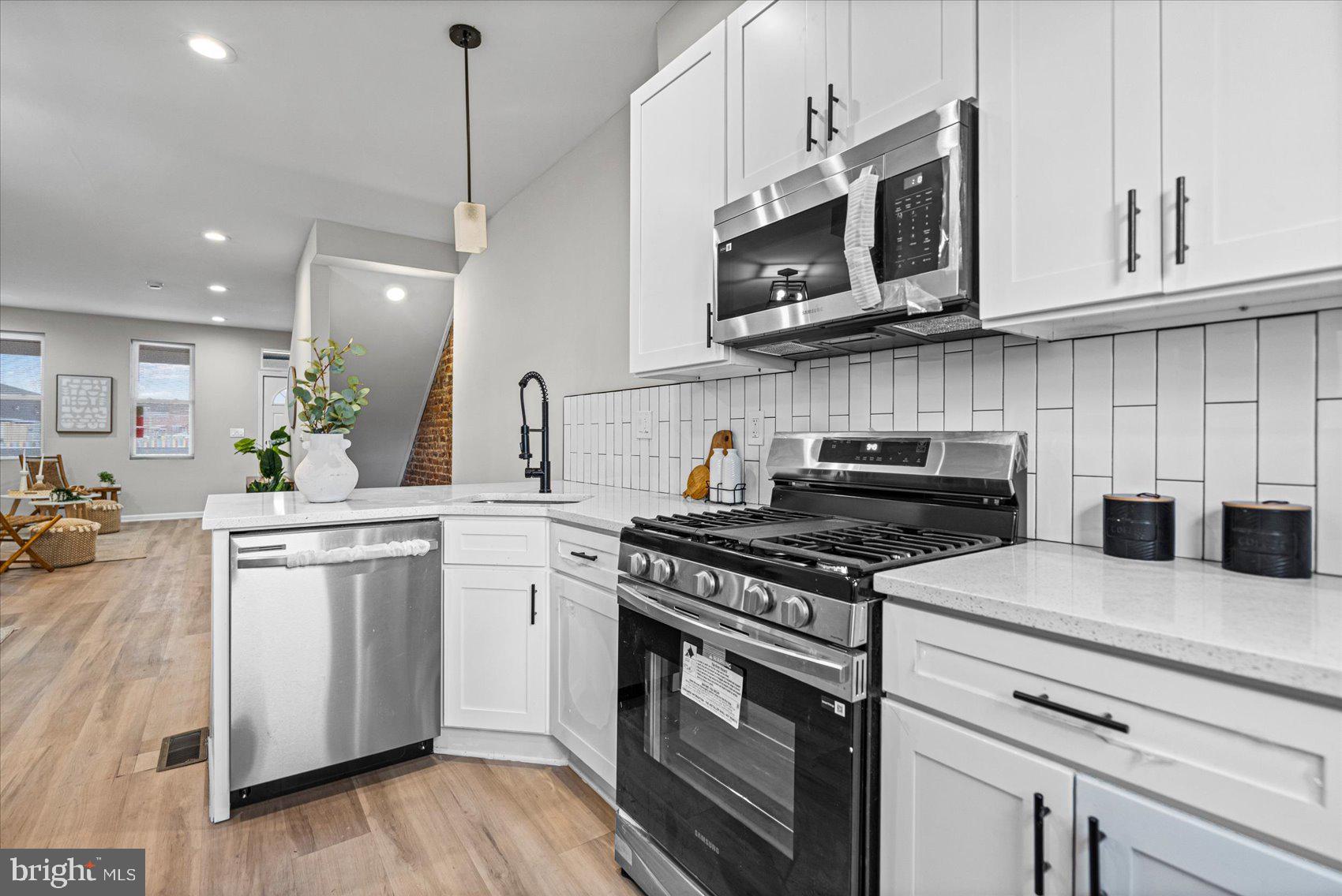 13 South Hilton Street Baltimore, MD 21229 - Photo 12 of 48 a kitchen with stainless steel appliances granite countertop a stove a sink and a microwave