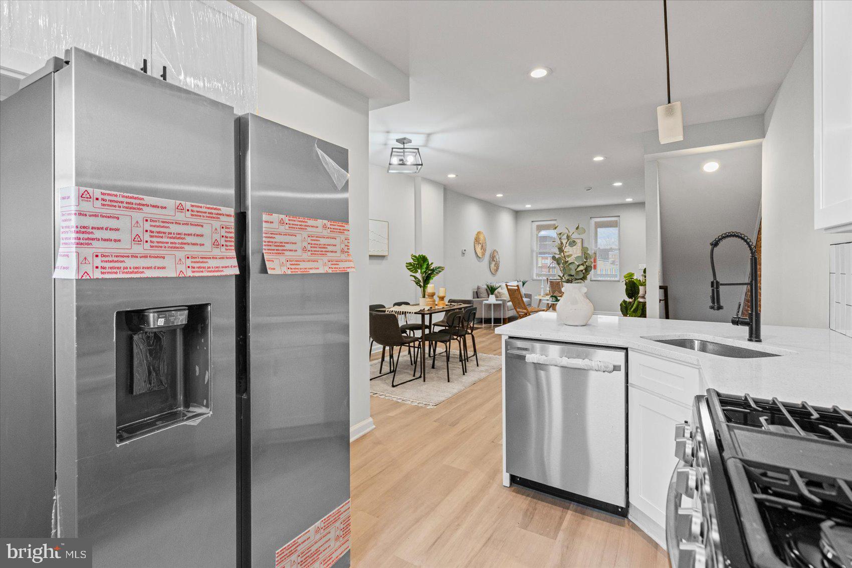 13 South Hilton Street Baltimore, MD 21229 - Photo 13 of 48 a kitchen with stainless steel appliances a dining table chairs stove and cabinets