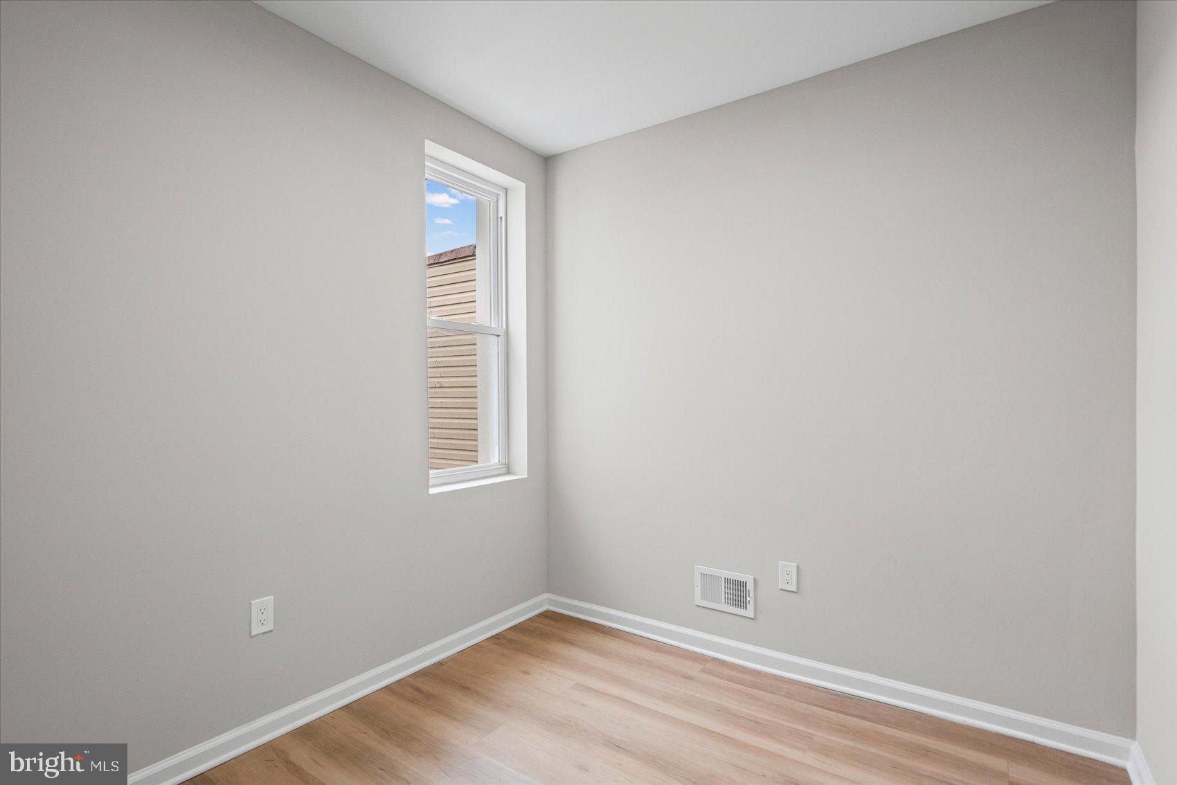 13 South Hilton Street Baltimore, MD 21229 - Photo 25 of 48 a view of an empty room with wooden floor and a window