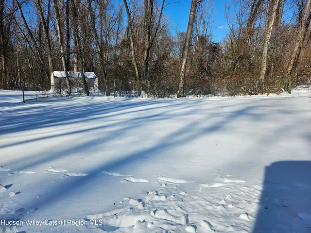 a view of white house with snow on the road