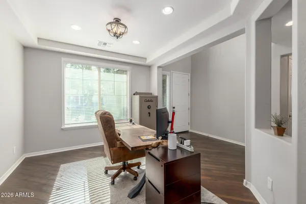 a living room with a bed and a dresser with wooden floor