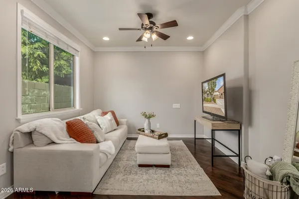 a view of an empty room with a window and chandelier fan