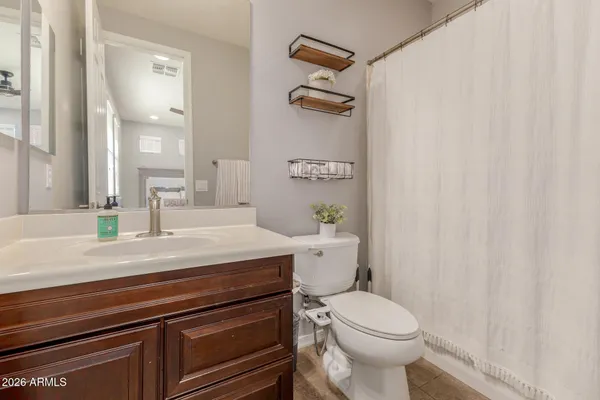 a bathroom with a granite countertop toilet a sink and a mirror