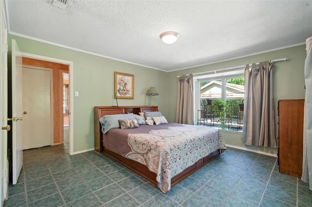 702 Keywe Place Duncanville, TX 75116 - Photo 21 of 40 a bedroom with a bed lamp and a large window