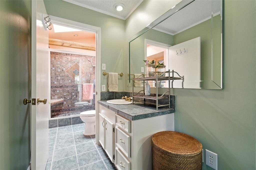 702 Keywe Place Duncanville, TX 75116 - Photo 23 of 40 a bathroom with a sink a toilet a mirror and shower