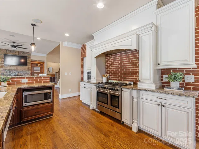 a kitchen with stainless steel appliances granite countertop a stove and a sink
