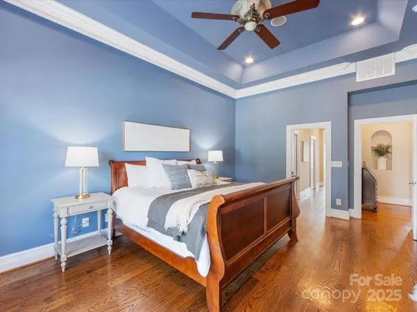 a bedroom with bed and wooden floor