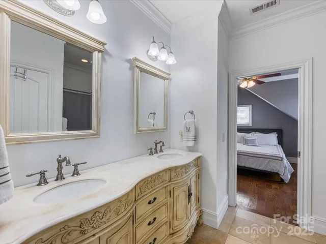 a en suite bathroom with a granite countertop sink and a mirror