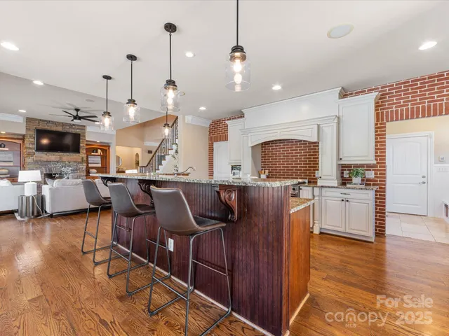 a kitchen with stainless steel appliances kitchen island granite countertop a stove a sink and a refrigerator