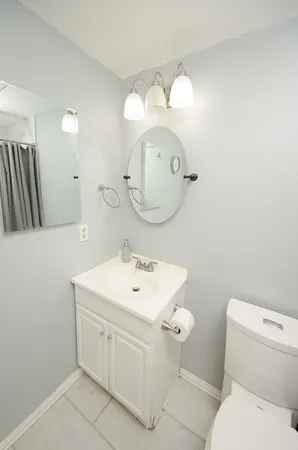 a bathroom with a toilet sink and mirror