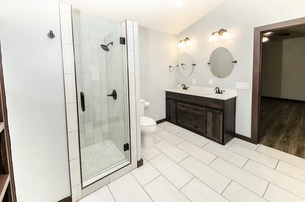 a bathroom with a sink mirror and shower