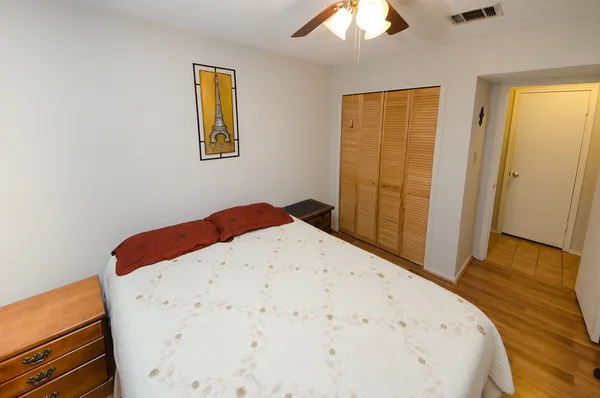 a bedroom with a bed and wooden floor