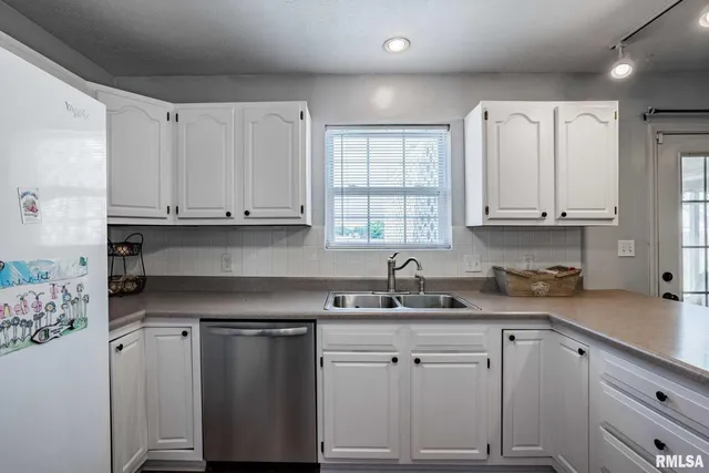 a kitchen with stainless steel appliances granite countertop a sink a stove and cabinets