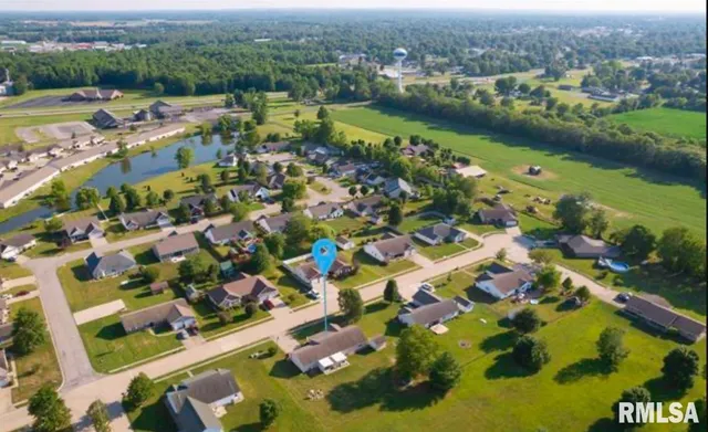an aerial view of residential houses with outdoor space and lake view