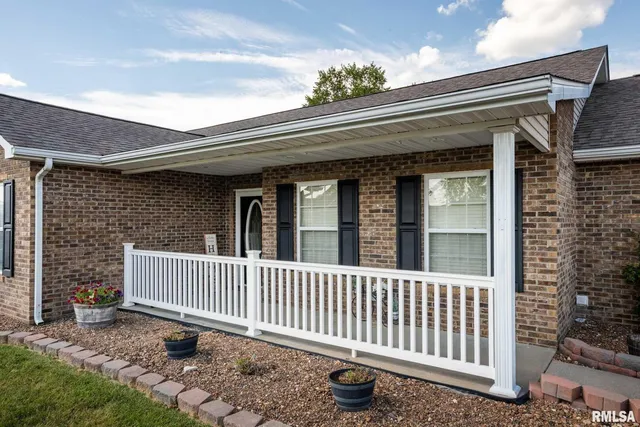 a view of a house with a small yard and wooden fence and a bench