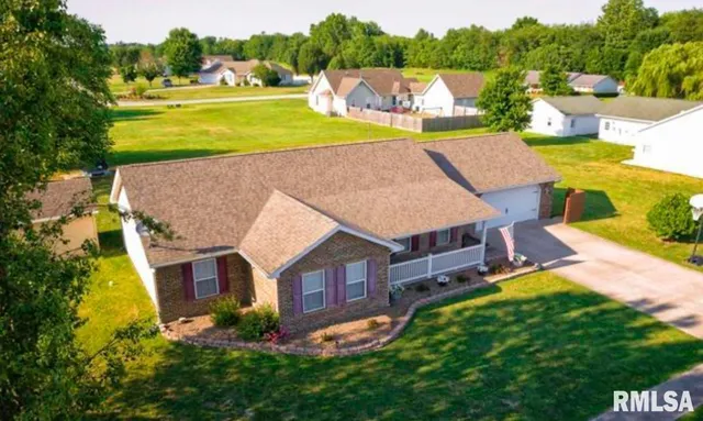 an aerial view of a house with a garden and a yard