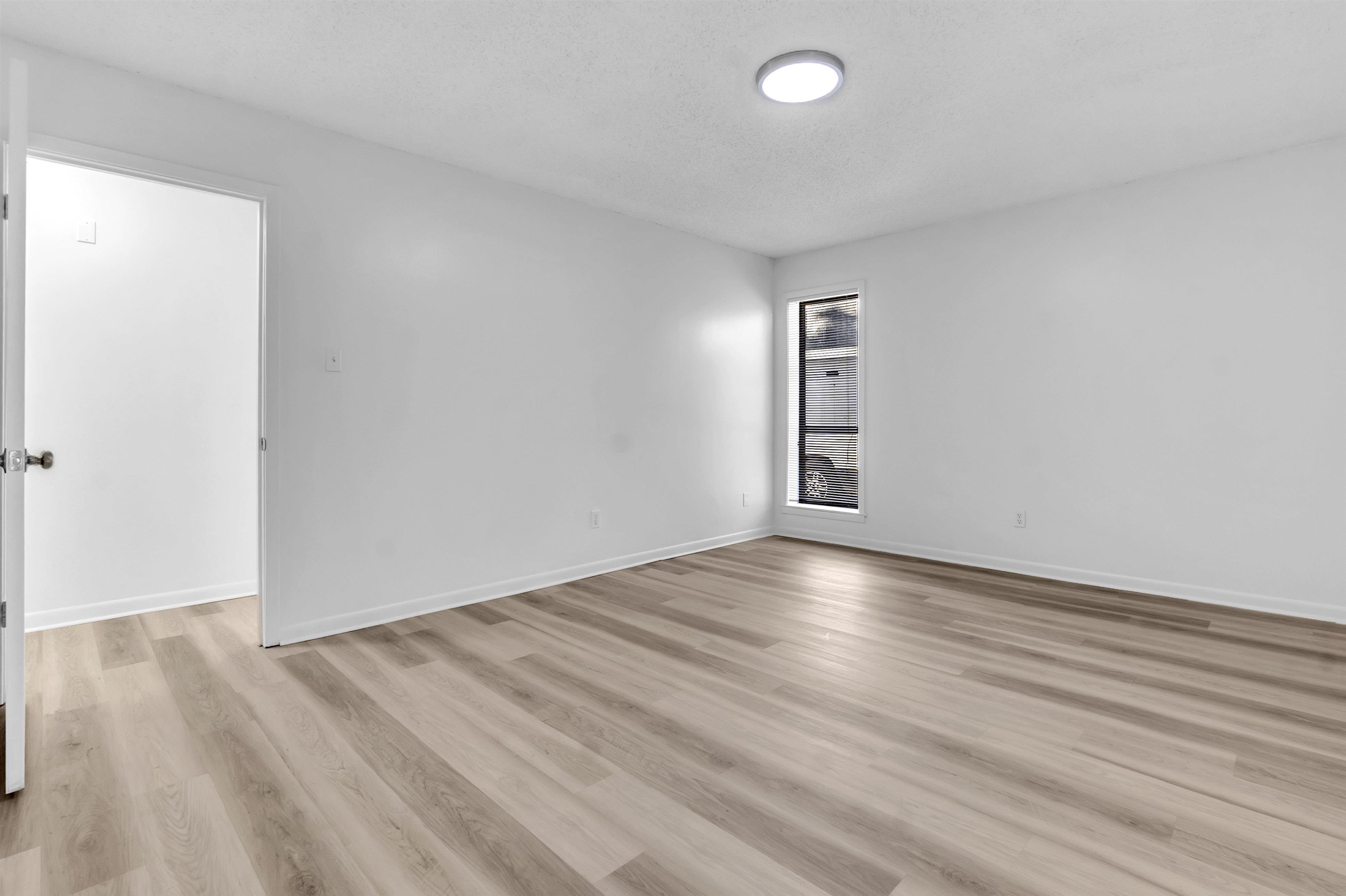 4579 Crump Road Memphis, TN 38141 - Photo 6 of 18 an empty room with wooden floor and windows