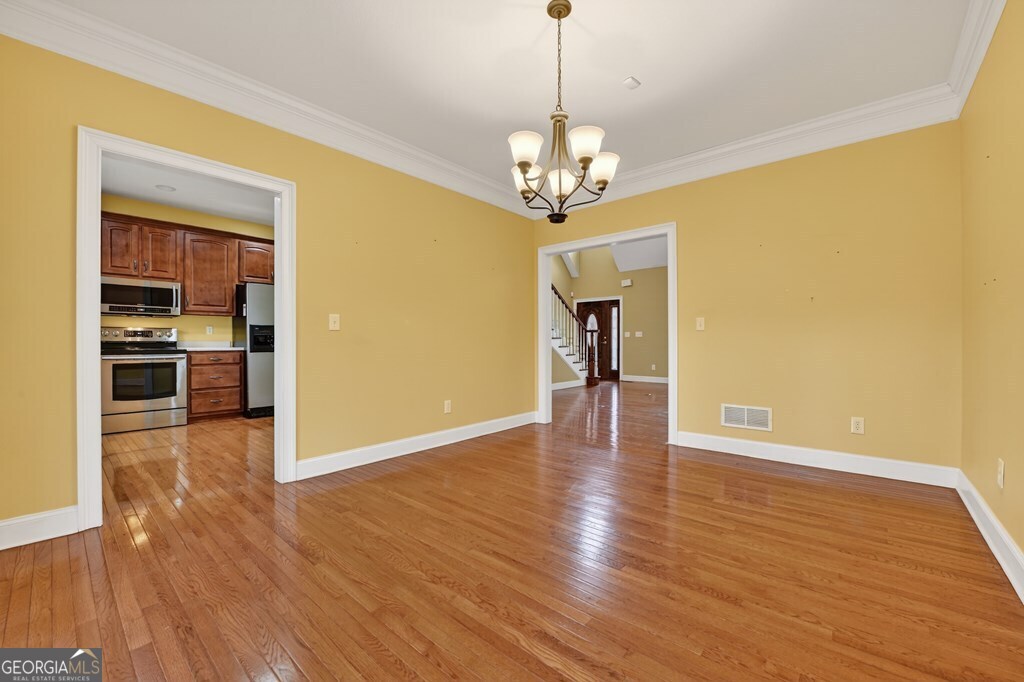 220 Oak Ridge Road Ellijay, GA 30536 - Photo 12 of 36 a view of a livingroom with wooden floor a ceiling fan and kitchen space