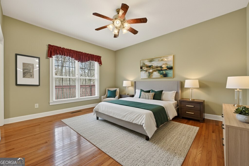 220 Oak Ridge Road Ellijay, GA 30536 - Photo 14 of 36 a spacious bedroom with a bed and a painting on the wall