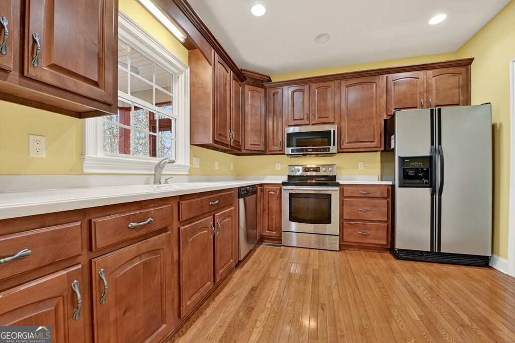 220 Oak Ridge Road Ellijay, GA 30536 - Photo 7 of 36 a kitchen with granite countertop wooden floors stainless steel appliances and sink