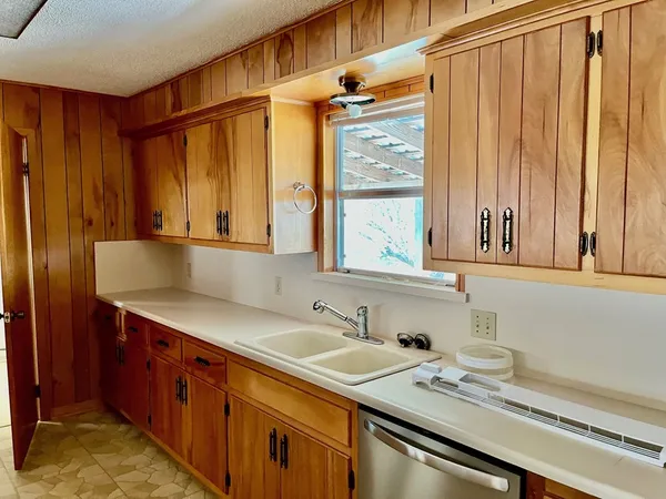 a kitchen with a sink cabinets and a window