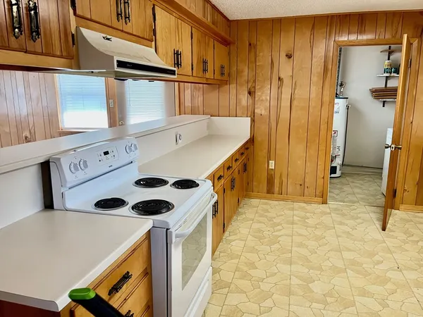 a kitchen with stainless steel appliances granite countertop a sink a stove and a refrigerator
