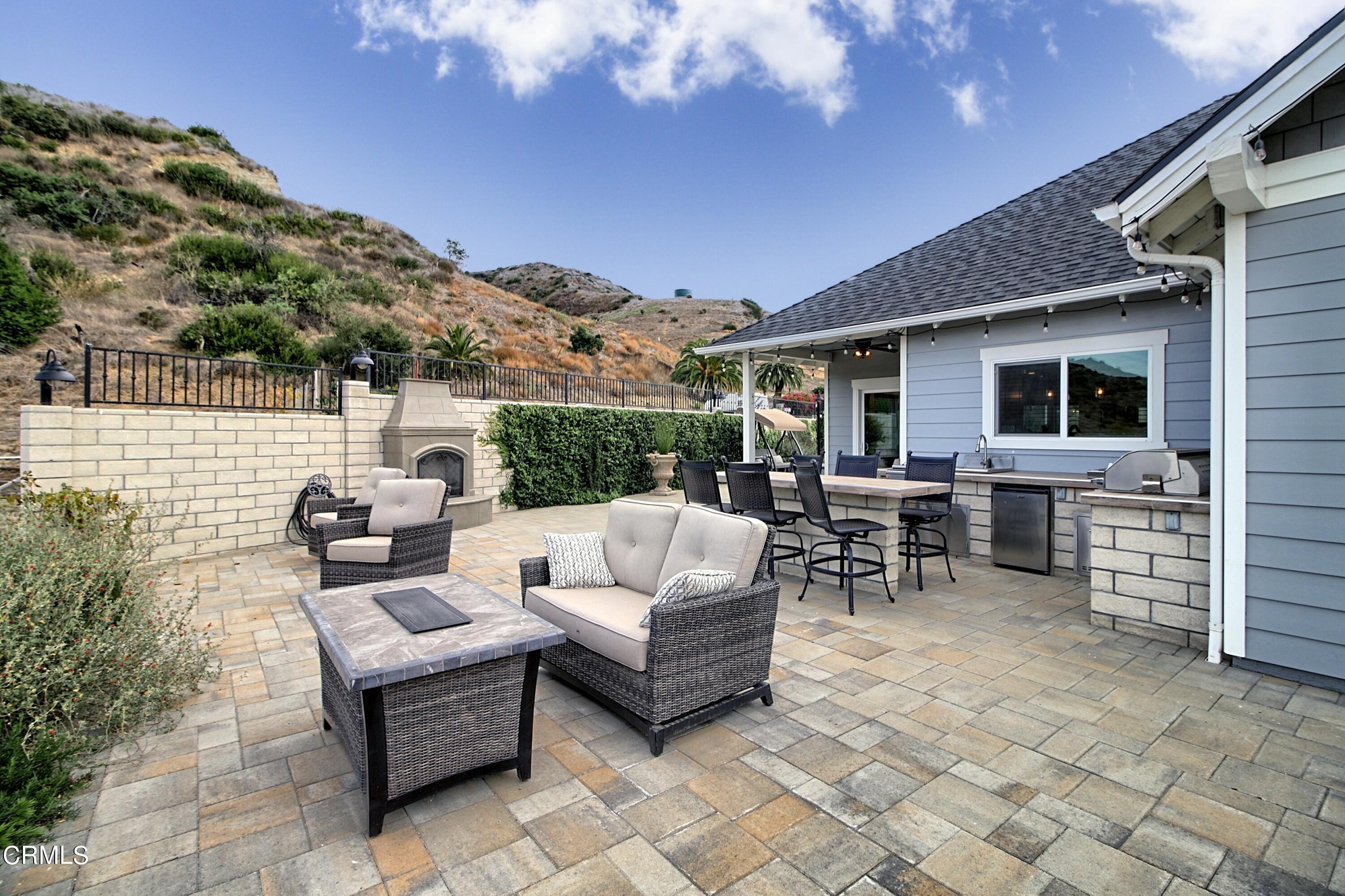 357 Los Cabos Lane Ventura, CA 93001 - Photo 26 of 44 a view of a patio with couches dining table and chairs with wooden fence