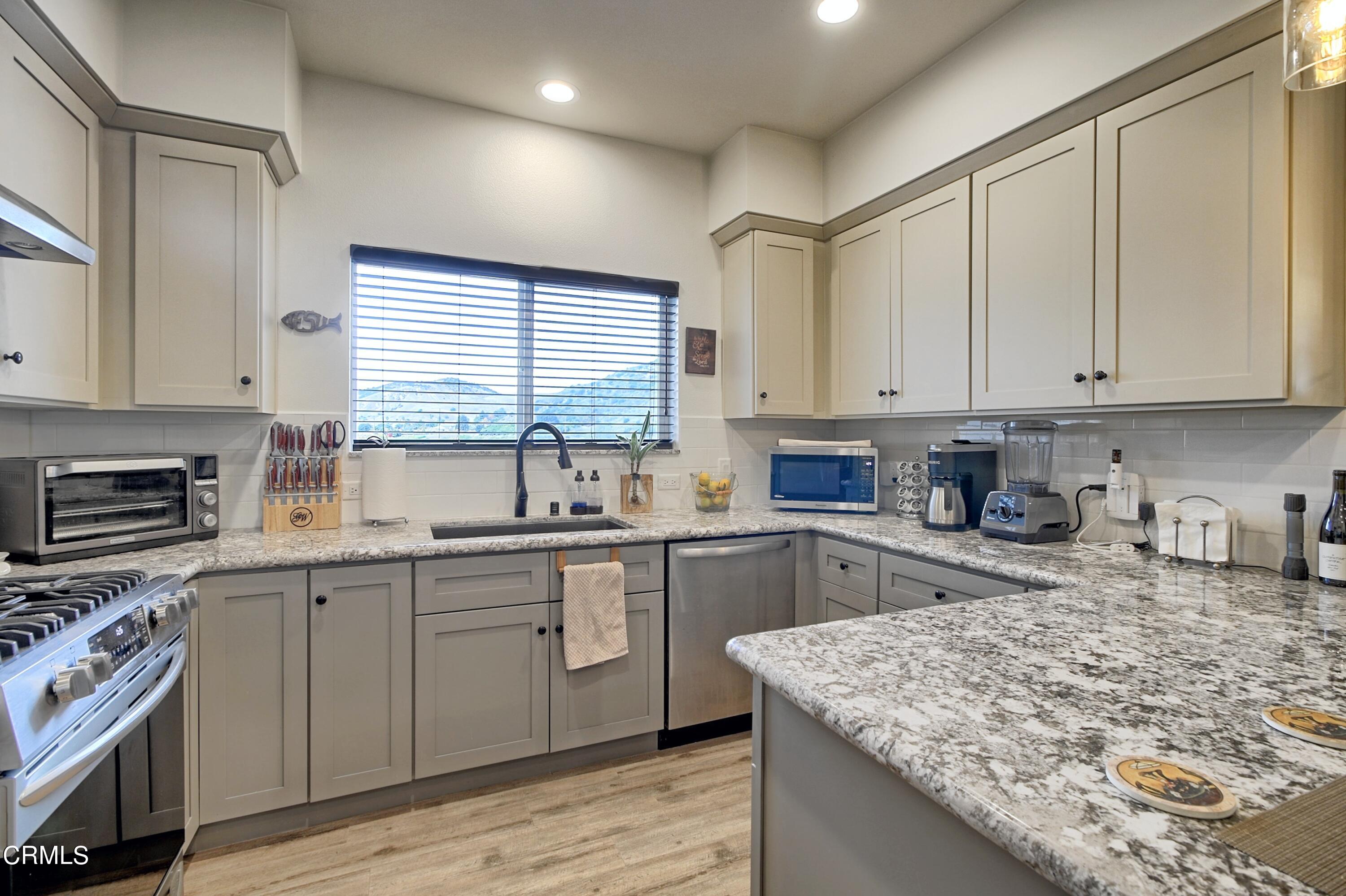 357 Los Cabos Lane Ventura, CA 93001 - Photo 10 of 44 a kitchen with stainless steel appliances granite countertop a sink stove and cabinets