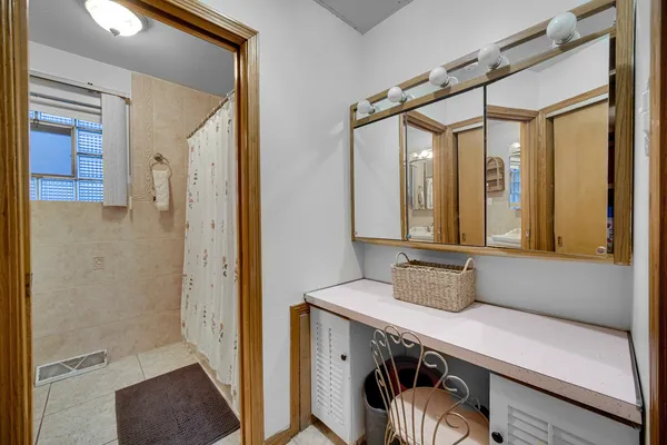 a bathroom with a tub a sink and a large mirror