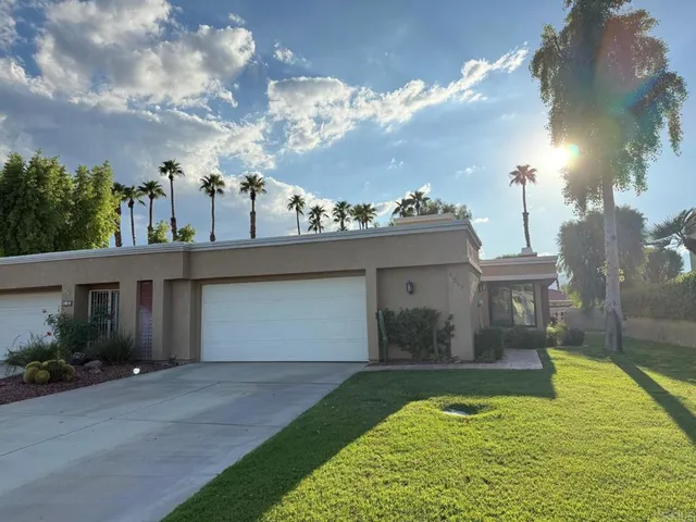 a view of a house with a yard and a garage