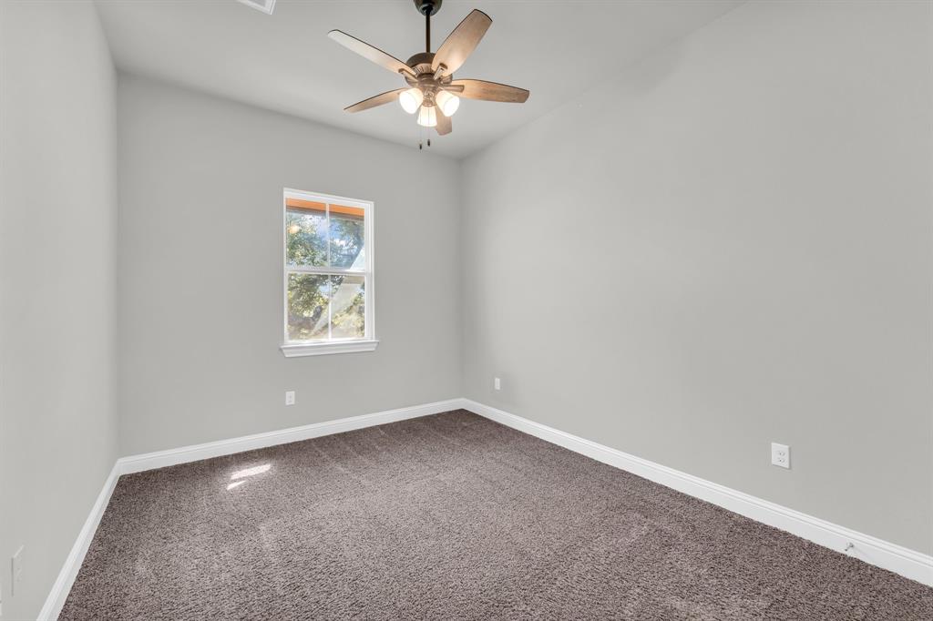 110 Magona Trail Georgetown, TX 78628 - Photo 29 of 38 A quiet bedroom offers ample space and plush carpet, perfect for peaceful rest.