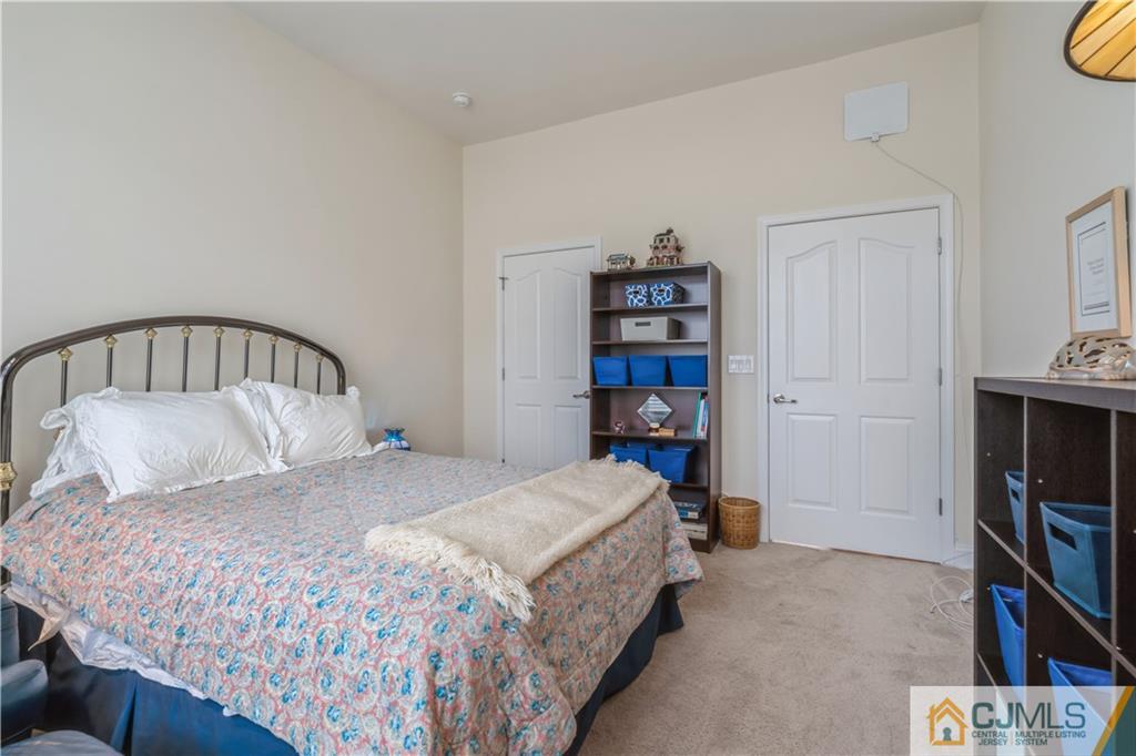 118 Cobblestone Boulevard Monroe Township, NJ 08831 - Photo 19 of 34 a bedroom with a bed a book shelf and a shelf