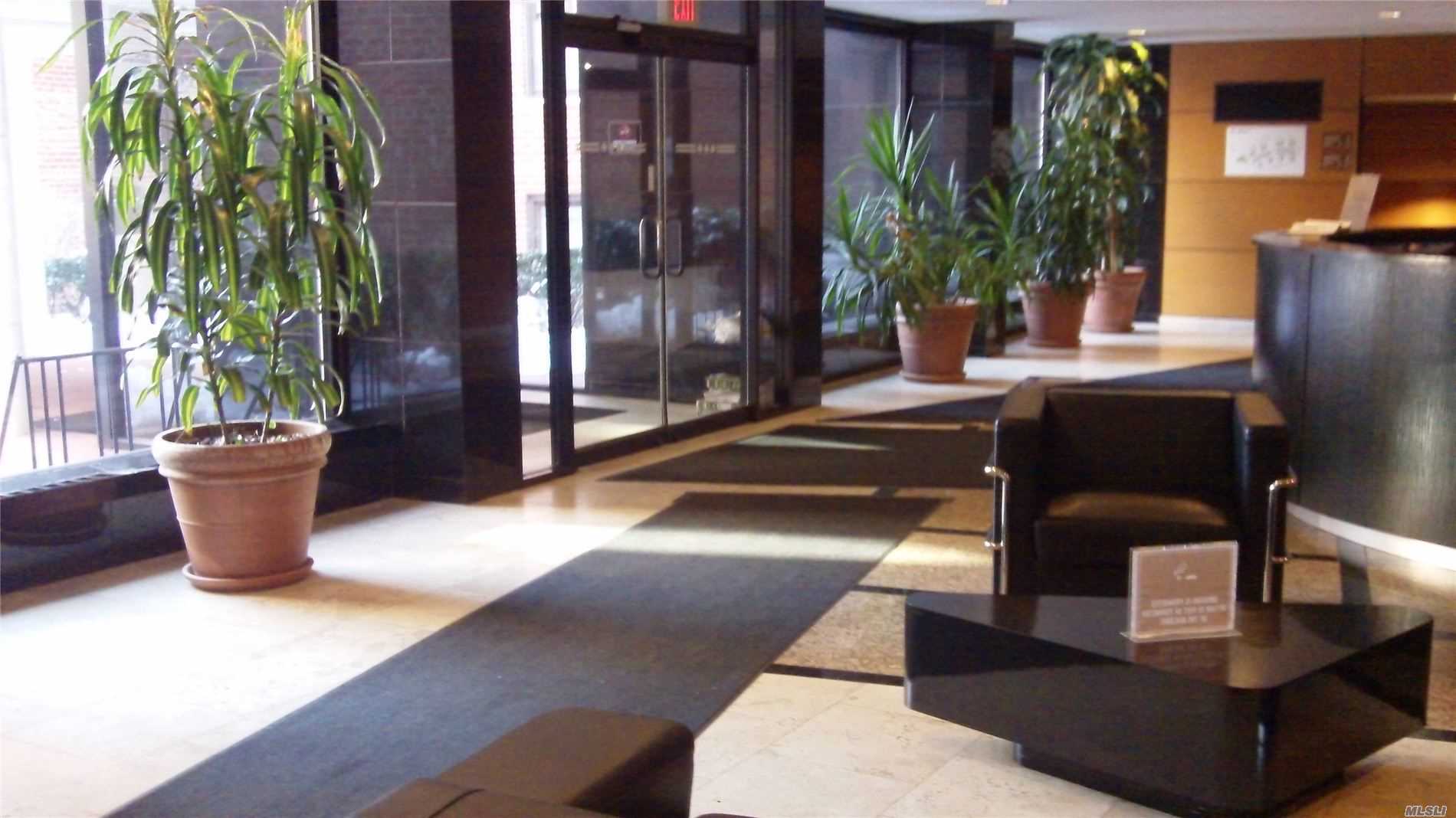 a view of a lobby with chair and potted plants