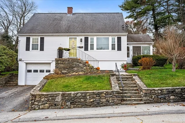 a front view of a house with a yard and potted plants