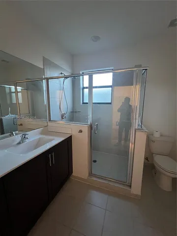 a bathroom with a double vanity sink toilet and shower