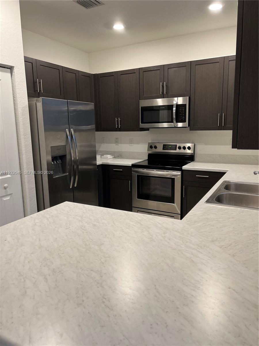 13387 Southwest 287th Terrace Homestead, FL 33033 - Photo 3 of 50 a kitchen with granite countertop a refrigerator and a sink