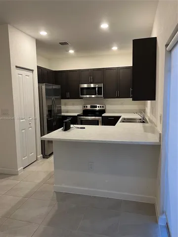 a kitchen with a refrigerator and a car