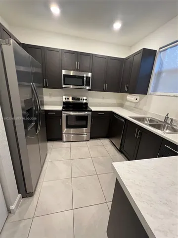a kitchen with stainless steel appliances a sink counter space cabinets and a counter top space